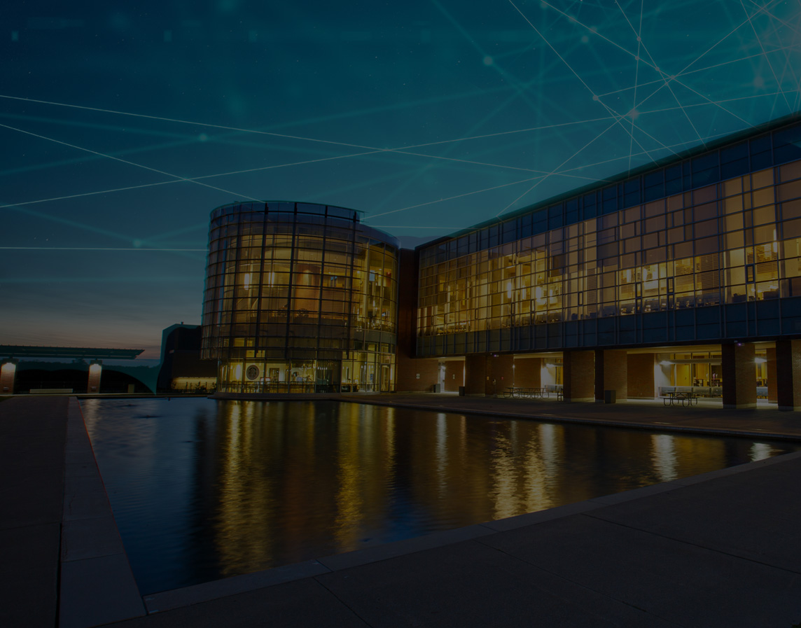 Campus building at night with tech graphic overlay